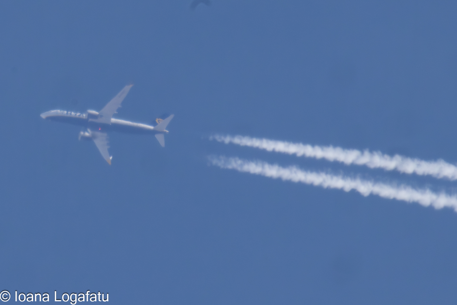 Jet soaring high with trails in the clear sky